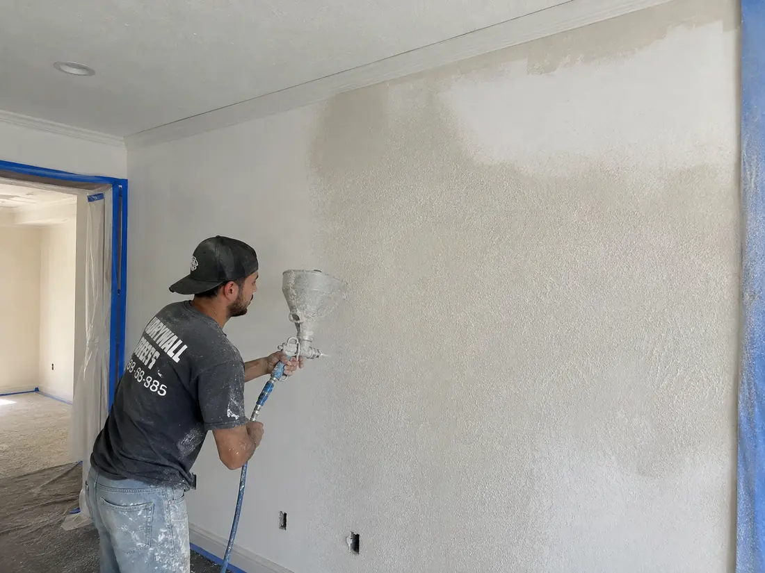 Spray texture being applied to a drywall wall